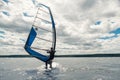 The guy in the waggon swims on the windsurf on lake