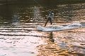 The guy on the Wakeboard rides on the river at sunset. Krasnogorsk, Russia - 08.09.2019 Royalty Free Stock Photo