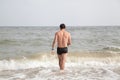 Guy walking into the sea