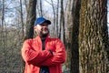 A guy walking in the woods. Bearded man in the forest. Portrait of a guy in a cap among the trees. Portrait of a young bearded man