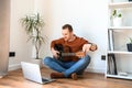 A guy watches video tutorial on guitar playing Royalty Free Stock Photo