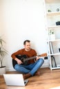 A guy watches video tutorial on guitar playing Royalty Free Stock Photo
