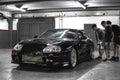 Guy are watching a Black Toyota Supra biturbo. Royalty Free Stock Photo