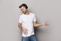 Guy wearing headphones imitating playing guitar posing studio shot