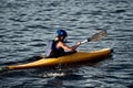 A guy wearing a helmet on a canoe polo rowing a paddle and sailing on water. canupolo. puts on a rescue yellow. rear view. water