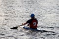 A guy wearing a helmet on a canoe polo rowing a paddle and sailing on water. canupolo. puts on a rescue yellow. sportswear