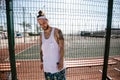 Guy with white headband on his head and tattoos on his arms dressed in the white t-shirt, black leggings and blue shorts Royalty Free Stock Photo