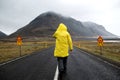 guy in a yellow cloak is walking down the road in the mountains, a tourist. The concept of freedom.