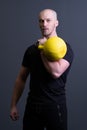 Guy with a yellow kettlebell gym anonymous workout strength, from fit teenager from picking from resitance youth Royalty Free Stock Photo