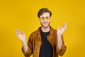 guy with yellow sunglasses posing on a yellow background