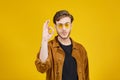 guy with yellow sunglasses posing on a yellow background