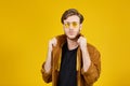 guy with yellow sunglasses posing on a yellow background