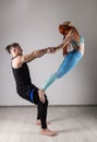 Guy and young woman doing strength exercises in yoga assanes. Acroyoga concept