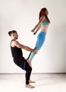 Guy and young woman doing strength exercises in yoga assanes. Acroyoga concept