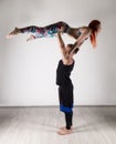 Guy and young woman doing strength exercises in yoga assanes. Acroyoga concept