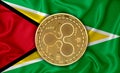 GUYANA flag, ripple gold coin on flag background. The concept of blockchain, bitcoin, currency decentralization in the country. 3d