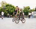 Guys cycling in the town square. Without a helmet