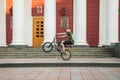 Guys cycling in the town square. Without a helmet