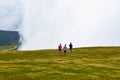 Guys go on the plateau surrounded by fog and low clouds near Transalpina road in Romania Royalty Free Stock Photo