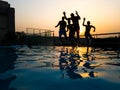 Guys jumping into water with the sunset Royalty Free Stock Photo