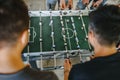 Guys are playing table football view from above. table football soccer with white and blue players