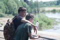 Guys relax in the park in the summer near the river. Brothers on a walk in the park near the lake.