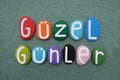 Guzel Gunler, turkish sentence meaning Nice Days composed with multi colored stone letters