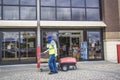 A worker gathers shopping carts with full PPE protection on