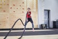 Gym battle rope woman stamina training Athlete guy fitness exercising endurance indoor workout Royalty Free Stock Photo