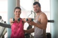 Gym Coach Helping Woman On Shoulder Exercise