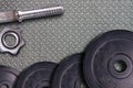 Gym hard dumbbell and weights. Stel sport equipment on metal gym floor background.