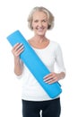 Gym instructor holding blue exercise mat