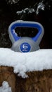 Gym kettlebell weight in a deep snow.