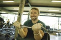 Gym lifestyle portrait of young athletic and attractive man smiling happy and natural training biceps muscle pulling weight bar at Royalty Free Stock Photo