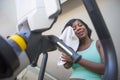 Gym portrait of young attractive and happy black African American woman training at fitness club holding towel drying sweat smilin Royalty Free Stock Photo