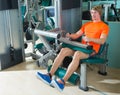 Gym seated leg curl machine exercise blond man Royalty Free Stock Photo