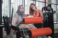 Gym seated leg curl machine exercise muslim women hijab Royalty Free Stock Photo