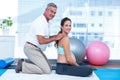 Gym trainer massaging happy pregnant woman Royalty Free Stock Photo