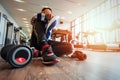 The gym trainer sitting on the ground and hold Small towel. A dumbbell near the gym trainer.