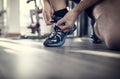 Gym workout routine man tying running shoes shoelace preparing for a jog or physical exercise Royalty Free Stock Photo