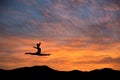 Gymnast doing the splits jump in sunset