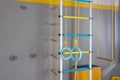 Gymnastic climbing wall with rings, crossbar, ladder of yellow, blue, white color in the child's room Royalty Free Stock Photo