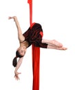 Gymnastic girl exercising on red fabric rope