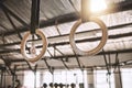 Gymnastic rings hanging in a gym. Empty gym with workout equipment. Acrobat rings hanging in a gym. Empty gym with