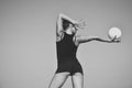 Gymnastic school and energy. Sport and success. Woman gymnast in black sportswear with green ball. Flexibility in Royalty Free Stock Photo