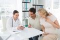 Gynaecologist and expectant couple looking at reports Royalty Free Stock Photo