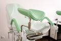 Gynecological chair with green footrests. Doctors office