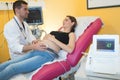 gynecologist checking female patients fetal life signs with ultrasound scanner