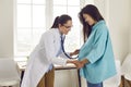 Gynecologist doctor examining heartbeat in the abdomen of pregnant woman with stethoscope. Royalty Free Stock Photo