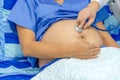 Gynecologist doctor hand checking pregnant young woman with stethoscope on bed in hospital, pregnant woman visit obstetrician doct Royalty Free Stock Photo